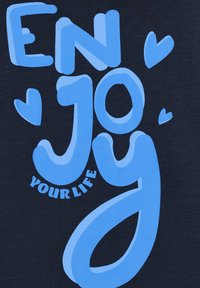 Camisa de un oscuro azul marino con gran texto azul que dice "DISFRUTA TU VIDA" con acentos de corazones. El diseño es audaz y juguetón con tamaños de fuente variados.