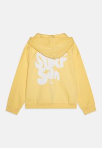 Sudadera con capucha amarilla hecha de algodón suave. Presenta un gran texto blanco "SURF SUN" en la parte posterior. Incluye puños y dobladillo acanalados.