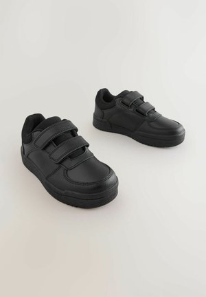 Zapatillas negras con parte superior de cuero liso y doble tira de velcro. Punta redondeada y suela de goma texturizada para mayor agarre.