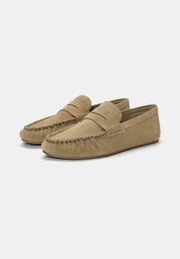 Mocassini da uomo in suede color cammello con cuciture in stile mocassino e dettaglio della fascia a penny, mostrati uno accanto all'altro su uno sfondo chiaro.