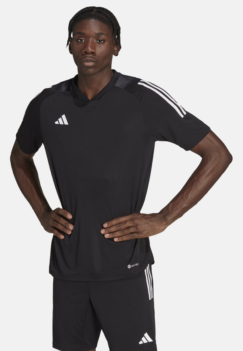 Schwarzes Sporttrikot mit kurzen Ärmeln, Mesh-Struktur, Rundhalsausschnitt und weißen Drei-Streifen-Akzenten auf den Schultern. Getragen mit passenden schwarzen Shorts.