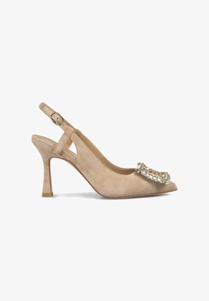 Beige suède slingback pump met een puntige neus, voorzien van een decoratieve kristalversiering aan de voorkant en een middelhoge hak.
