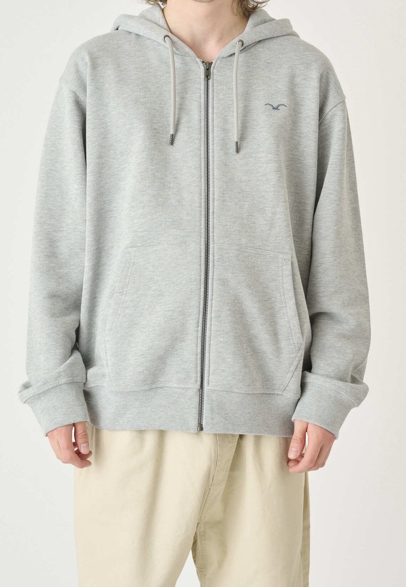 Grå zip-up hoodie i en mjuk bomullsblandning, med kengurufickor, dragsko på huvan, ribbade ärmslut och en liten logotypdetalj på bröstet.