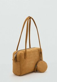Borsa color giallo senape con motivo coccodrillo, forma rettangolare, due manici lunghi e una pochette rotonda staccabile con cerniera.
