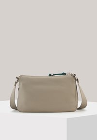 Beige nylon crossbody bag with adjustable strap, zip closure, and green accent detail. Smooth texture and minimalist rectangular shape.