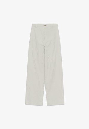 Pantaloni largi bej deschis cu dungi verticale subțiri, nasture frontal, bucle pentru curea și închidere cu fermoar, așezați pe o suprafață albă.