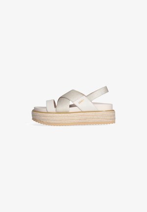 Sandali platform color beige chiaro con cinturini incrociati. Accento dorato texturizzato, suola spessa intrecciata e battistrada in gomma per una buona aderenza. Design casual.