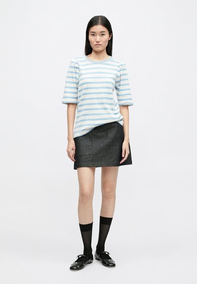 Μπλε και λευκή ριγέ μπλούζα με κοντό μανίκι, σκούρα τζιν φούστα, μαύρα παπούτσια και κάλτσες μέχρι το γόνατο, με απλό σχέδιο και εφαρμοστή σιλουέτα.