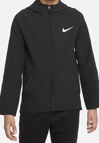 Czarna kurtka Nike z kapturem, z pełnym zamkiem błyskawicznym i bocznymi kieszeniami. Posiada białe logo Nike na lewej piersi. Gładki, lekkiego materiału.