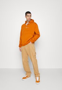 Karl Kani SMALL SIGNATURE HOODIE UNISEX - Camisola - cognac