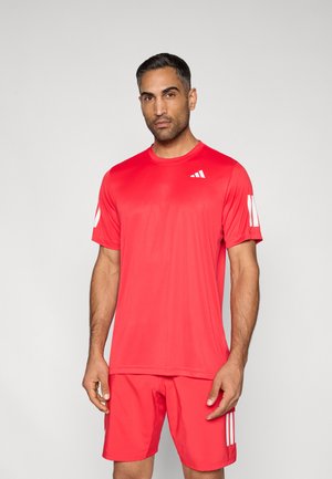 Chemise de sport rouge à manches courtes, col rond, comportant trois rayures blanches sur la manche gauche, assortie à un short rouge.