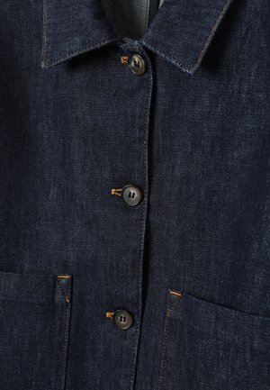 Dunkle Jeansjacke mit spitzem Kragen, Knopfleiste vorne mit kontrastierenden Nähten und zwei Fronttaschen.