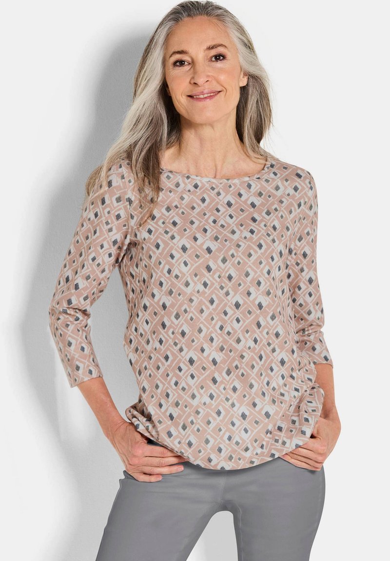 Lichtroze blouse met patroon met een ruitdesign in grijs en wit. Ronde halslijn en driekwartmouwen. Zacht materiaal.