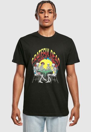 Black cotton t-shirt featuring a colorful print of skeletons playing cards at a table, with "GRATEFUL DEAD" text above and rose accents.
