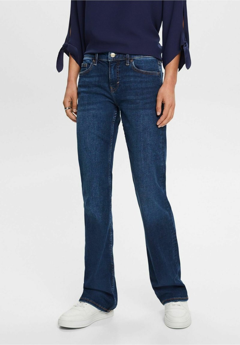 Jean bleu foncé à coupe droite, fabriqué en denim avec une légère élasticité. Comprend cinq poches et des accents en métal.