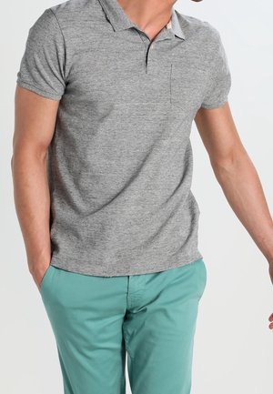 Polo gris à manches courtes avec col et poche poitrine, associé à un pantalon vert clair. Matière en mélange de coton, coupe décontractée.
