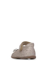 Zapatos de niña brillantes en dorado con puntera redondeada, interior suave y correa ajustable, que presentan un exterior texturizado y suela de goma plana.