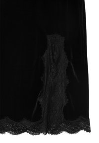 Schwarzer Samtrock mit einer Spitzenborte am Saum und einem Spitzenpaneel auf der linken Seite, mit einer glatten Textur und fließendem Design.