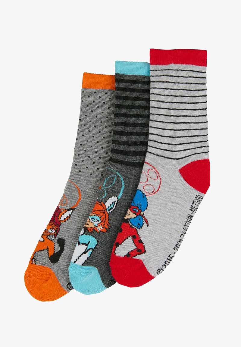 Tres pares de calcetines: grises con lunares, a rayas grises y blancas, y grises con personajes de dibujos animados coloridos. Cada uno tiene puños de colores distintos.