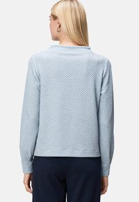 Maglione azzurro chiaro con texture a rombi, maniche lunghe e scollatura rotonda, caratterizzato da una vestibilità rilassata e polsini a costine.