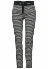 Black and white houndstooth patterned pants with a drawstring waistband, two zippered pockets, and tapered leg design.