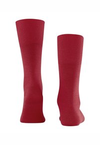 Punaiset sukat, joissa on resoripäällinen ja sileä pinta. Sukissa on yhtenäinen väri, nilkkapituus, eikä niissä ole kuvioita tai koristeita.