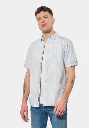 Chemise à manches courtes boutonnée en bleu clair avec un petit motif rouge, dotée d'une poche poitrine et de détails rouges contrastants le long de la patte de boutonnage.