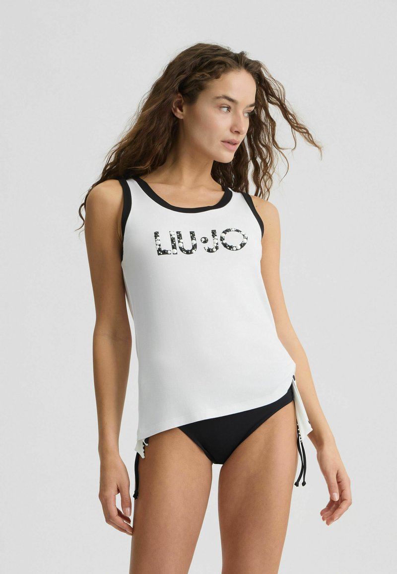 Débardeur blanc avec des accents noirs, arborant "LIU.JO" en sequins. Accompagné d'un bas de bikini noir, présentant un design sportif et élégant.