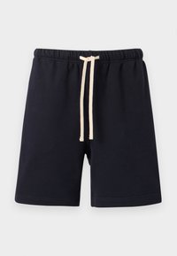 Μαύρα σορτς με ελαστική μέση και μπεζ κορδόνι, μήκους μέχρι το γόνατο, κατασκευασμένα από απαλό ύφασμα, σε απλό φωτεινό φόντο.