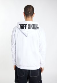 Biała bluza z kapturem z dużą czarną grafiką "TUFF SKULL" na plecach, z sznurkiem do regulacji kaptura oraz ściągaczami u dołu i na rękawach.