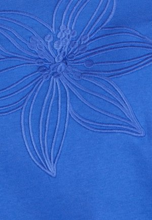 Tela azul con un diseño de flores en relieve. La flor tiene pétalos detallados y un centro texturizado, creando un efecto de relieve en la superficie.