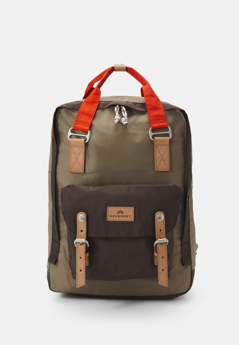 Olive green backpack with brown front pocket, red handles, and leather accents. Features silver hardware and a drawstring closure.