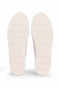 Jasnoróżowe gumowe podeszwy sneakersów z teksturowanym wzorem grip, wytłoczone logo na powierzchni oraz białe boki.