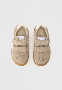 Pantofi bej pentru copii cu curele velcro, partea superioară din piele întoarsă și plasă, cu vârf perforat, talpă de cauciuc și accente cu marcă.