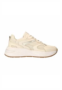 Beige sportieve schoenen met een gestructureerde synthetische overlay, vetersluiting, zilveren accenten en een dikke witte zool met een rubberen onderkant.