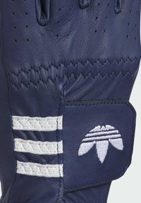 Marineblå læderhandsker med hvide vandrette striber, perforeret tekstur og et karakteristisk logo-patch. Forstærket syning hele vejen igennem.