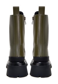 Paire de bottes mi-mollet en cuir vert olive avec semelles compensées noires épaisses et tirettes à glissière à l'arrière, vues de dos.