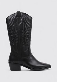 Bota de vaquero de cuero negro con punta afilada, diseño de rayo cosido y tacón bloque de altura media. Cuenta con una pestaña para facilitar el calzado.