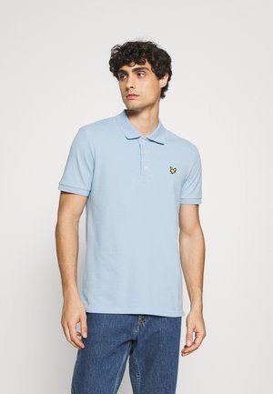 Light blue polo shirt made of cotton, featuring a collar and short sleeves. It has a small yellow butterfly logo on the left chest.
