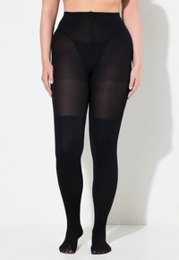 Collant neri con una texture a coste, vita alta e design senza piedi, che presenta sezioni trasparenti e opache per un contrasto visivo unico.