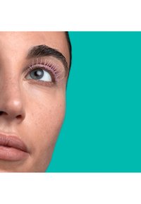 Zbliżenie oka z różowym tuszem do rzęs na długich rzęsach, na tle jasnoturkusowym. Skóra ma naturalną teksturę i odcień.