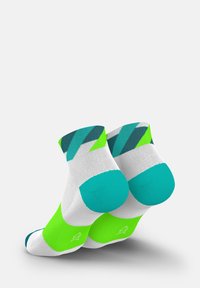 Schwarzschenkel-Socken mit weißem Grund, lebhaften grünen Akzenten und einem geometrischen Muster in Türkis und Dunkelgrün am Bündchen.