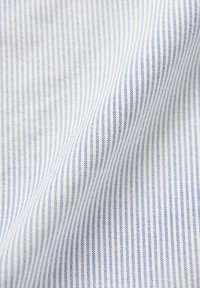 Tkanina w paski z cienkimi niebieskimi liniami na białym tle, gładka w fakturze, z subtelnym połyskiem wynikającym z splotu.