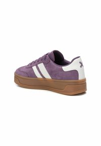 Zapatillas de ante moradas con diseño de rayas blancas, suela acolchada y suela de goma. Presenta logo en el talón y cierre con cordones.
