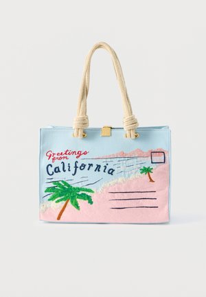 Tote bag bleu clair avec poignées en corde crème, brodé avec l'inscription "Salutations de Californie", des palmiers et un design de carte postale de plage.