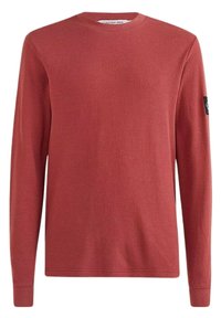 Roter Pullover mit langen Ärmeln, strukturiertem Strick, runder Ausschnitt und schwarzem Logo-Patch am linken Ärmel. Reguläre Passform, gerippte Bündchen und Saum.