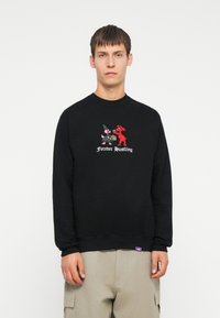 Felpa nera con personaggi colorati ricamati e il testo "Forever Hustling". Presenta un collo a giro e polsini e orlo a coste.