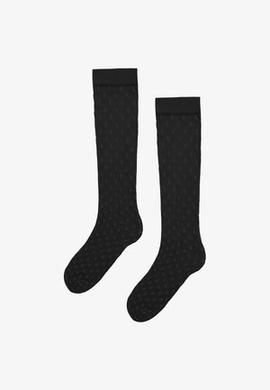 Paar schwarze knielange Socken mit dezentem kleinen Punktmuster auf weißem Hintergrund.