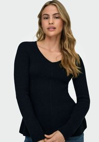 Jūras zila ribota adīta džemperis ar garām piedurknēm un V-veida kaklu. Iespējots pieguļošs dizains un izpušķots apakšmalas izskats, lai radītu izsmalcinātu izskatu.