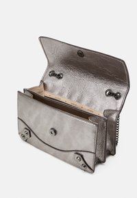 Metallisk grå lædertaske med en struktureret overflade, udstyret med klaplukning, trykknap og indvendige rum til organisering.